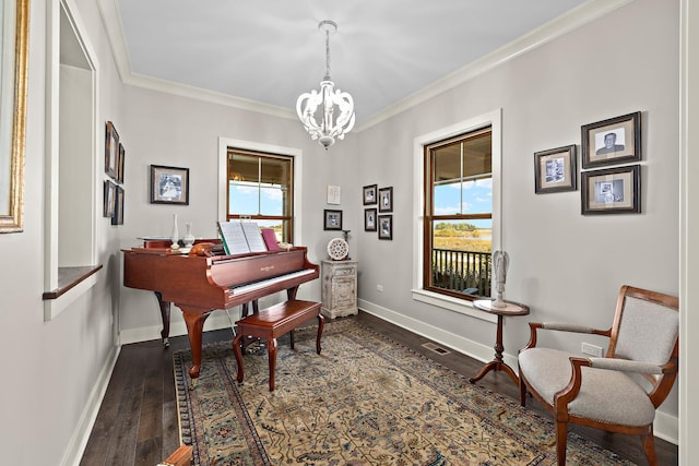 living area featuring a notable chandelier, crown molding, dark wood-type flooring, and a healthy amount of sunlight