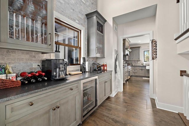 bar featuring wine cooler, gray cabinets, dark wood-type flooring, and tasteful backsplash