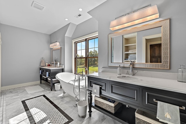 bathroom with lofted ceiling, vanity, and a tub