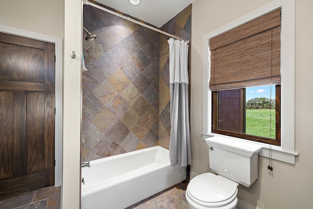 bathroom featuring shower / tub combo and toilet