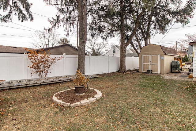 view of yard featuring a storage shed, an outbuilding, and a fenced backyard