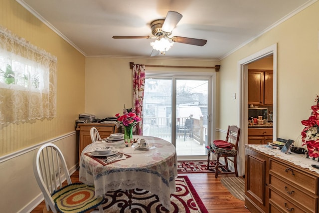 dining space featuring ornamental molding, dark wood-style flooring, and a ceiling fan