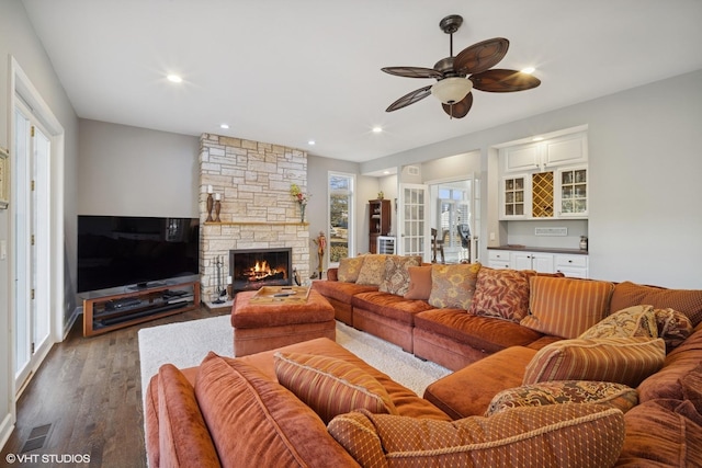 living room featuring dark wood-style floors, visible vents, a fireplace, recessed lighting, and ceiling fan