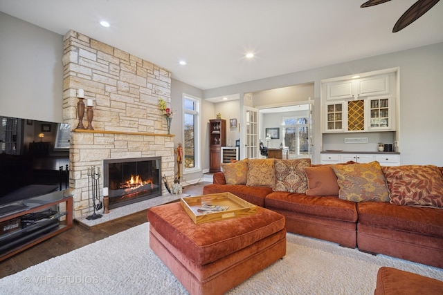 living area featuring recessed lighting, a ceiling fan, wood finished floors, and a fireplace