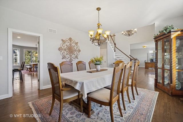 dining space featuring visible vents, baseboards, a notable chandelier, and wood finished floors