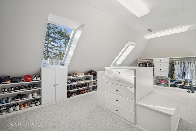 walk in closet featuring lofted ceiling, visible vents, and carpet floors