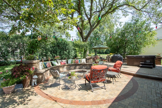 view of patio / terrace featuring an outdoor fire pit, a grill, and a hot tub