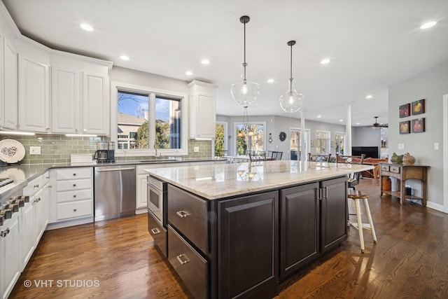 kitchen featuring dark brown cabinets, appliances with stainless steel finishes, dark wood-style floors, white cabinetry, and a sink