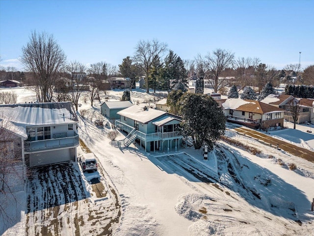 snowy aerial view with a residential view