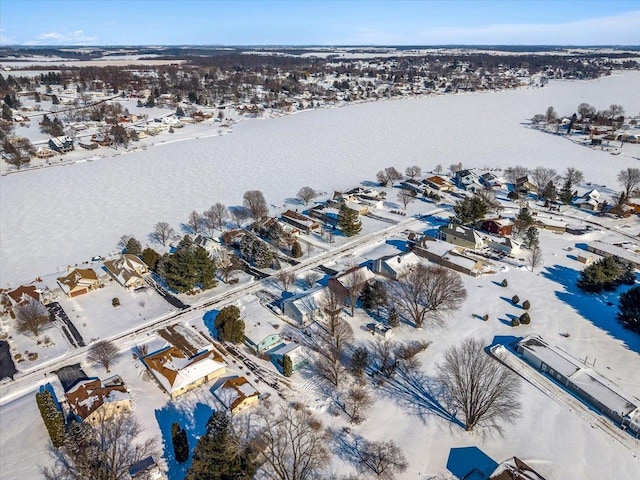 snowy aerial view with a water view and a residential view