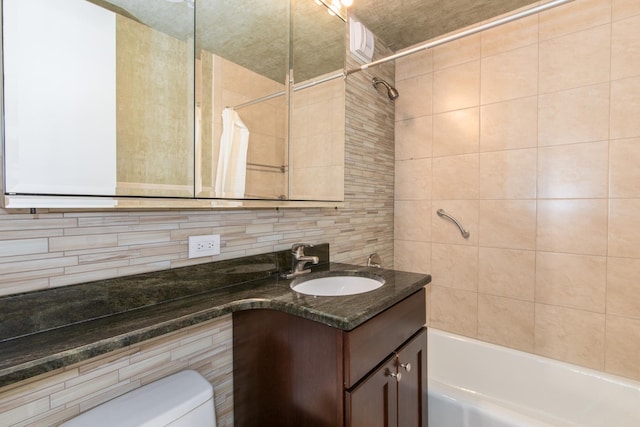 full bathroom featuring toilet, tile walls, vanity, shower / bath combination with curtain, and decorative backsplash