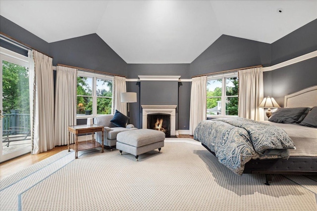 bedroom featuring vaulted ceiling, wood-type flooring, and access to exterior