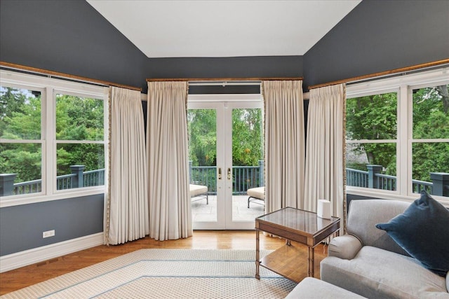 living room with vaulted ceiling, wood-type flooring, and french doors