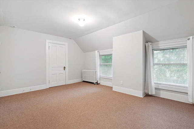 bonus room featuring lofted ceiling, light carpet, and radiator heating unit