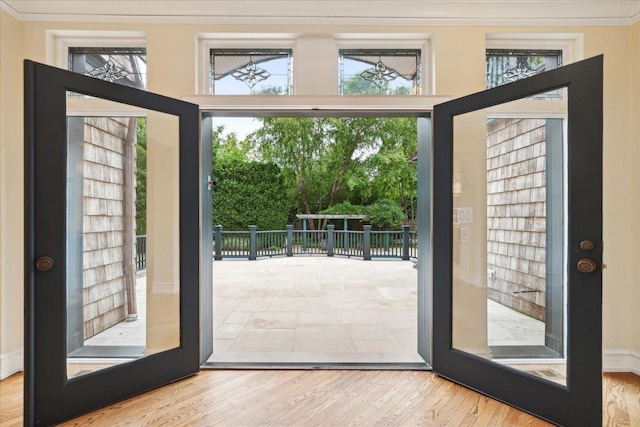 entryway featuring french doors, crown molding, a healthy amount of sunlight, and wood-type flooring