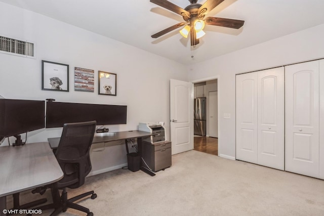 office space with light carpet and ceiling fan