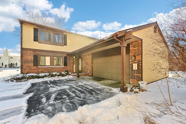 view of front of property with an attached garage, driveway, and brick siding