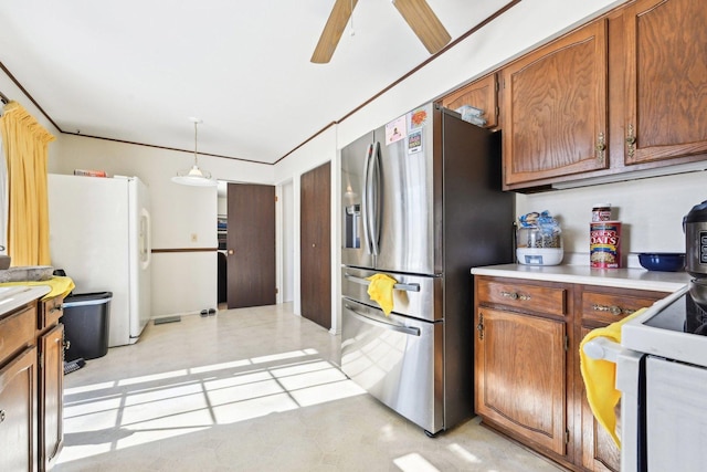 kitchen with white appliances, a ceiling fan, hanging light fixtures, light countertops, and brown cabinets