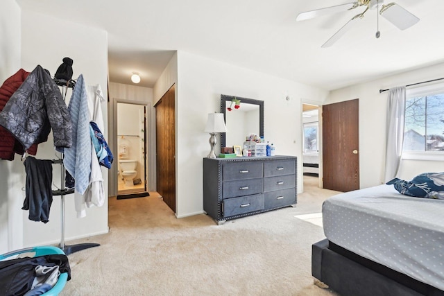 bedroom with light colored carpet, connected bathroom, and ceiling fan