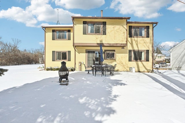 snow covered house featuring an outdoor fire pit