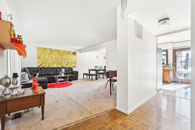 carpeted living area with visible vents and baseboards