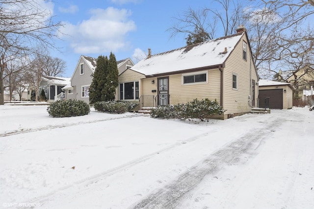 view of front of property featuring a garage, an outbuilding, and a chimney