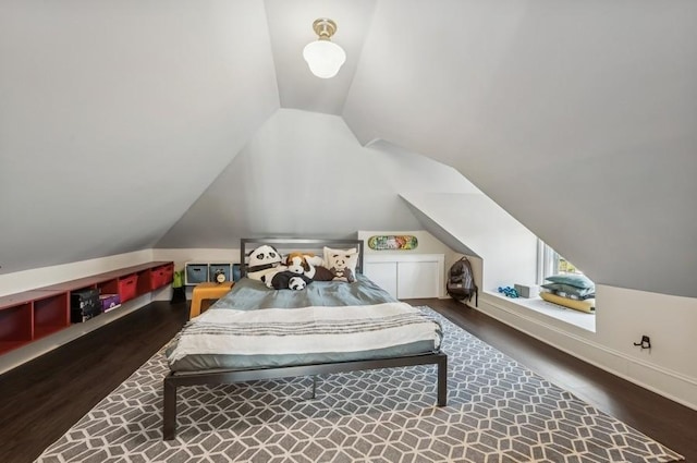 bedroom with dark wood-type flooring and lofted ceiling