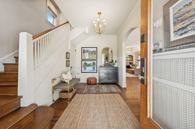 foyer with dark wood-type flooring and a notable chandelier