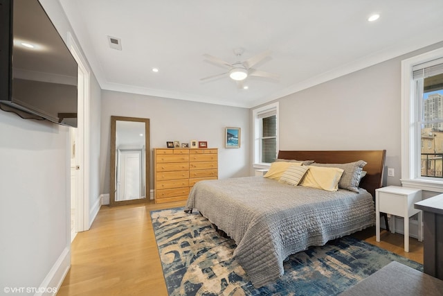 bedroom featuring light hardwood / wood-style flooring, ornamental molding, and ceiling fan