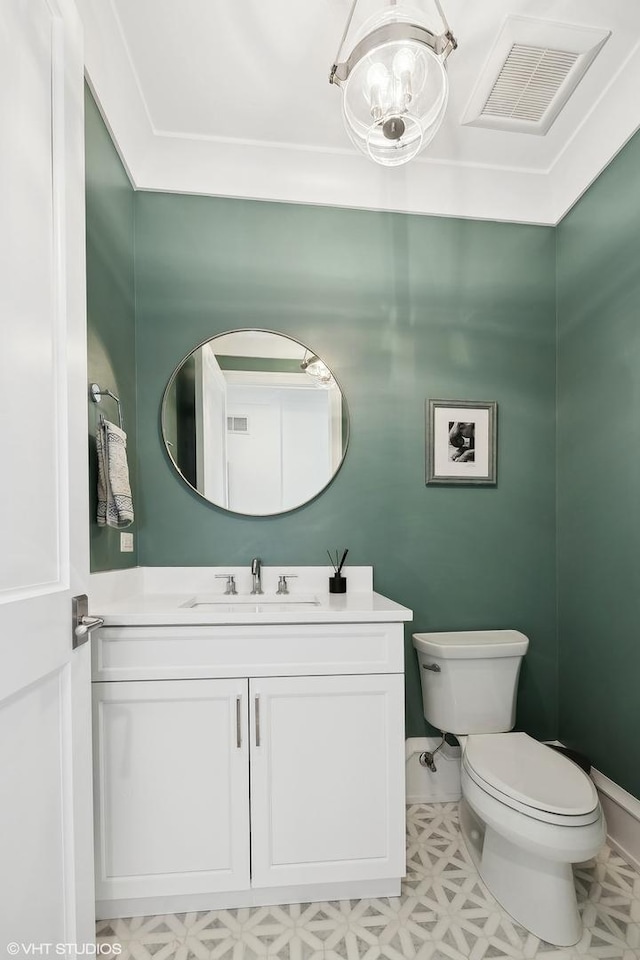 bathroom with an inviting chandelier, vanity, and toilet