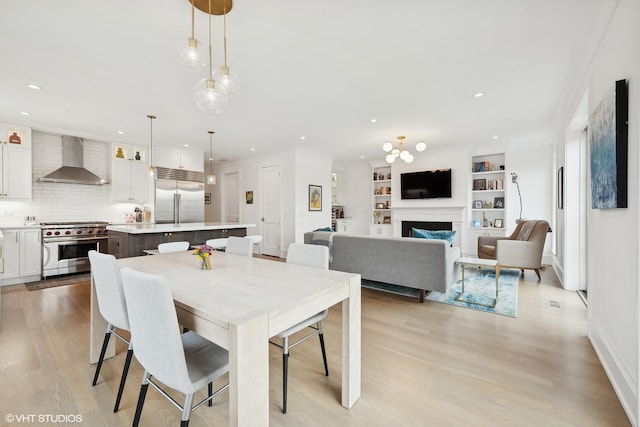 dining room featuring built in features and light wood-type flooring