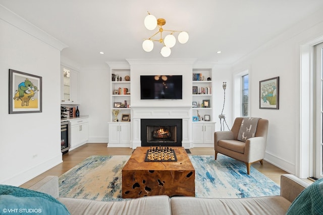 living room featuring ornamental molding, a chandelier, wine cooler, and light hardwood / wood-style floors