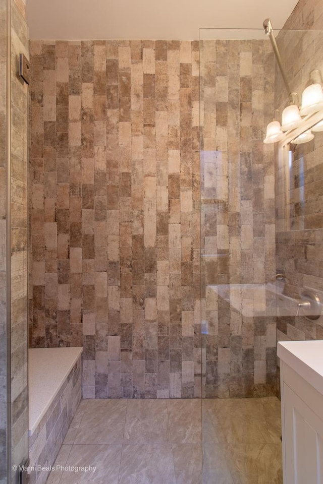 bathroom with vanity and a tile shower