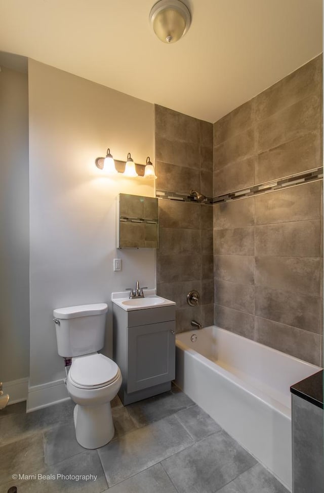 full bathroom with vanity, tiled shower / bath, tile patterned floors, and toilet