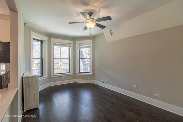 unfurnished room featuring ceiling fan, dark hardwood / wood-style flooring, and a wealth of natural light