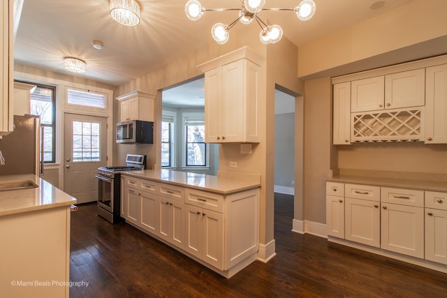 kitchen with white cabinetry, sink, stainless steel appliances, and dark hardwood / wood-style floors