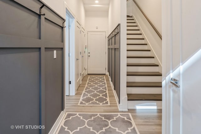 interior space featuring stairs, wood finished floors, and baseboards