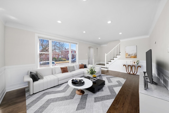 living room featuring stairway, recessed lighting, arched walkways, and wainscoting