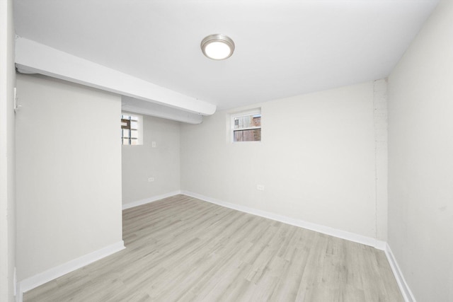 basement with plenty of natural light, baseboards, and light wood-style floors