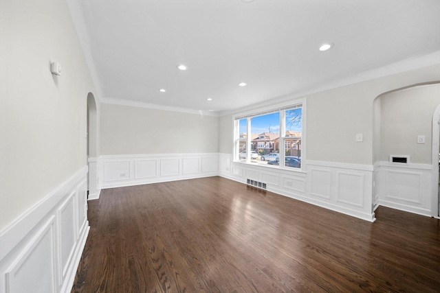 unfurnished living room featuring visible vents, arched walkways, dark wood-type flooring, and stairs