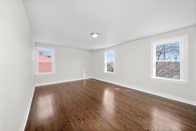 unfurnished room featuring baseboards and plenty of natural light