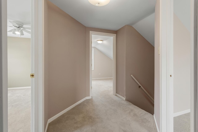 hallway with lofted ceiling and light colored carpet