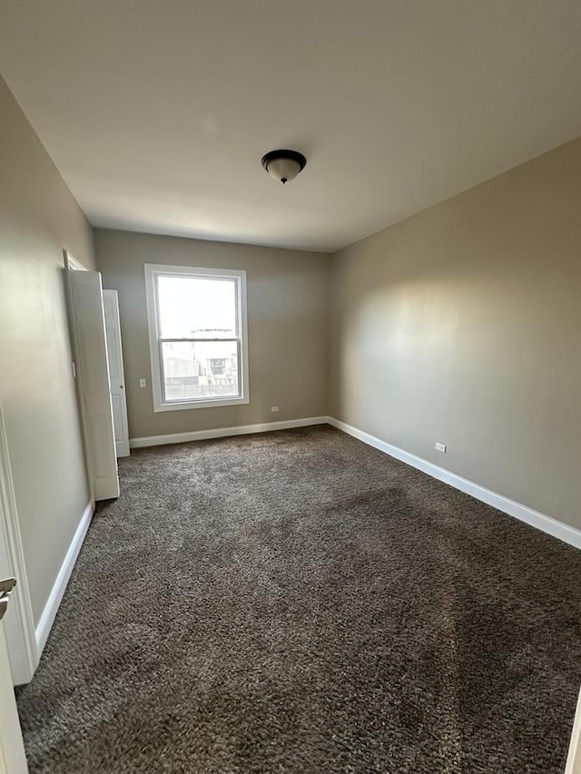 unfurnished room with dark colored carpet