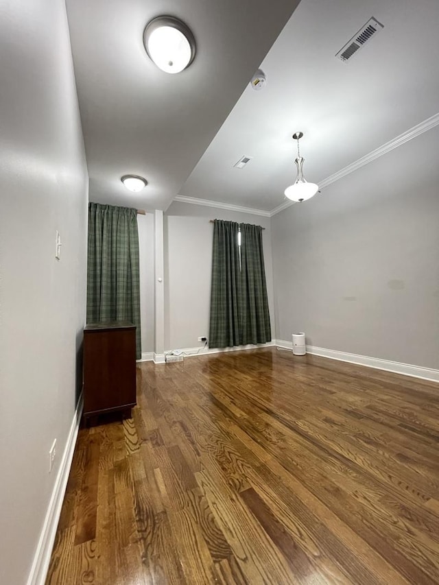 empty room with hardwood / wood-style flooring and ornamental molding