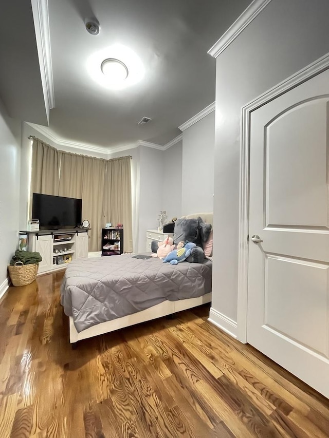 bedroom featuring ornamental molding and light hardwood / wood-style floors