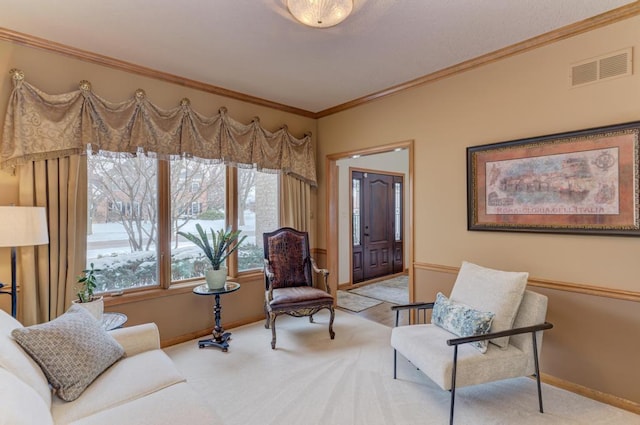 sitting room with ornamental molding and light colored carpet