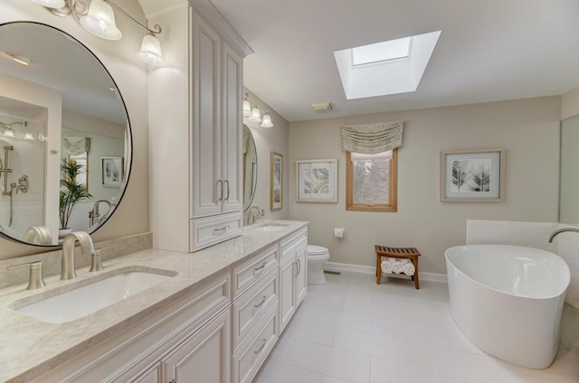 bathroom featuring a washtub, toilet, a skylight, and vanity