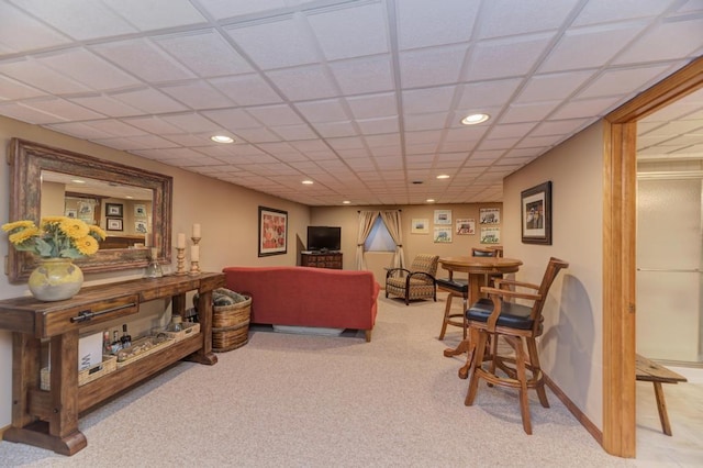 carpeted living room with a drop ceiling