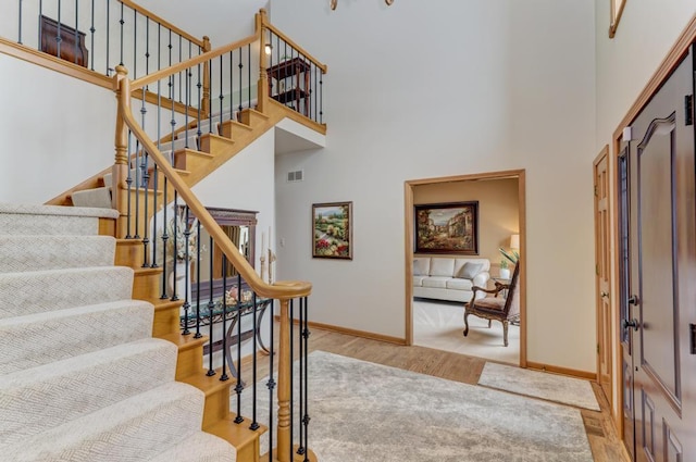 entryway featuring light hardwood / wood-style flooring and a towering ceiling