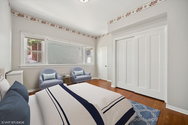 bedroom featuring multiple windows, baseboards, and wood finished floors